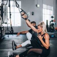 woman in black tank top and white pants sitting on floor